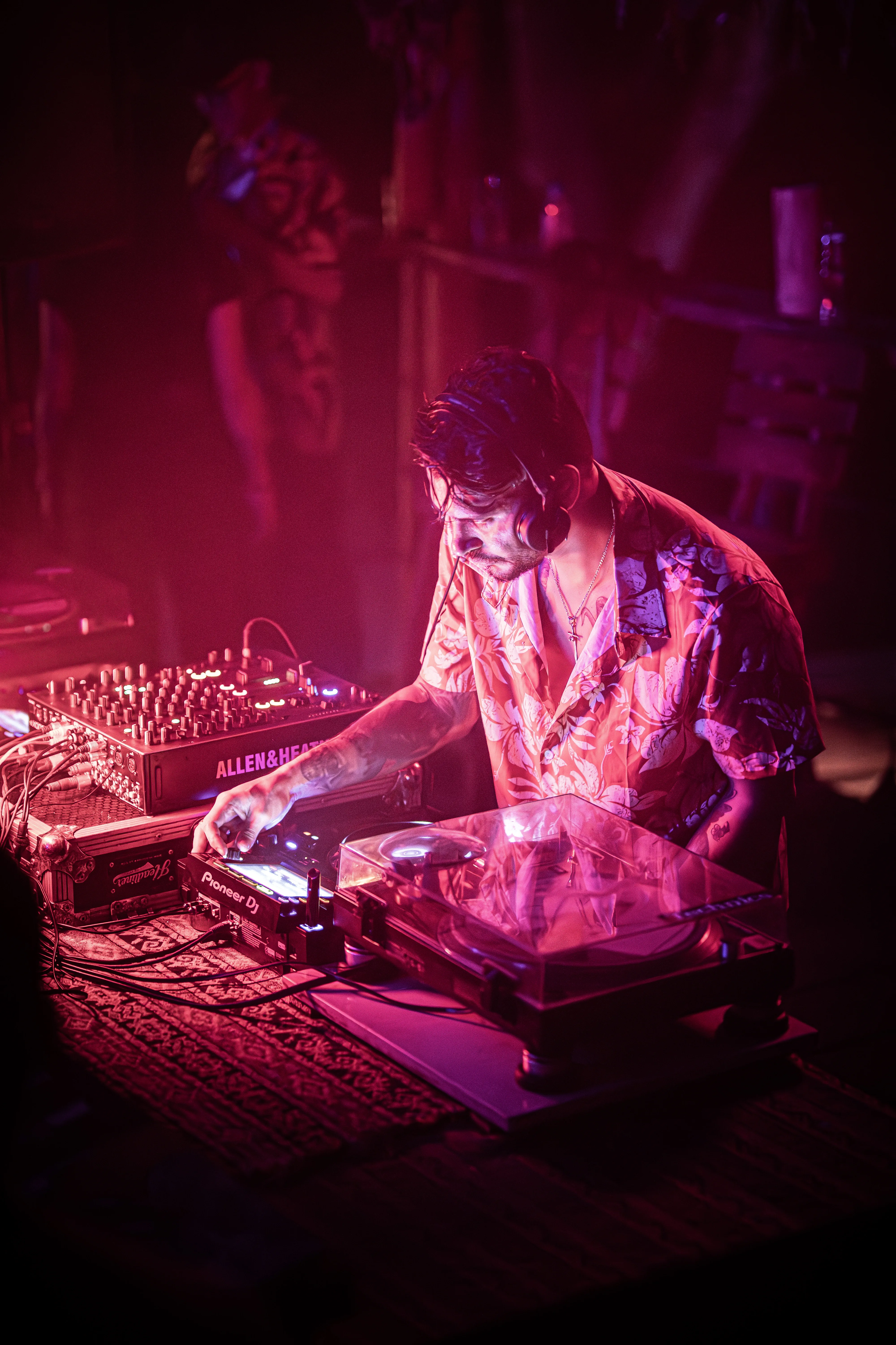 Cris Argotti at the booth under pink light